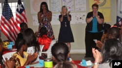 U.S. first lady Michelle Obama (L) is welcomed by Peace Corp teachers and students at a project 70 kilometers (43 miles) from the capital city Monrovia in Kakata, Liberia, June 27, 2016. 
