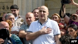 FILE - Opposition MP Nika Melia speaks to reporters outside the Tbilisi City Court, in Tbilisi, Georgia, June 27, 2019.