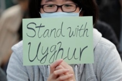 A man holds a sign during a rally to show support for Uighurs and their fight for human rights in Hong Kongy, Dec. 22, 2019.