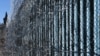 Border wall reinforced with barbed wire to prevent migrants from illegally entering into the United States. 
