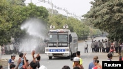 Police officers confront people protesting against the military coup, in Mandalay, Myanmar, Feb. 20, 2021.