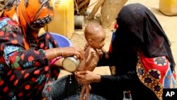 FILE - A severely malnourished infant is bathed in a bucket in Aslam, Hajjah, Yemen, Aug. 25, 2018.