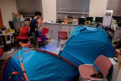 A volunteer medic searches for protesters inside a building on the campus of Hong Kong Polytechnic University, where dozens of pro-democracy protesters remain holed up, in the Hung Hom district of Hong Kong, Nov. 23, 2019.