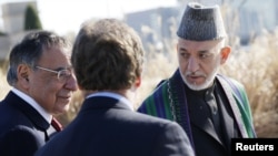 Afghanistan President Hamid Karzai (R) walks alongside U.S. Defense Secretary Leon Panetta (L) on a guided tour of the Pentagon Memorial, in memory of the victims of the September 11 attack, at the Pentagon, January 10, 2013.
