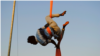 One of the Uganda's Hiccup Circus's aerialists gets into position to perform what's known as a 'drop'. This will send him on a breathtaking spin towards the ground, and is a common move during a routine's finale. (Elizabeth Paulat/VOA)