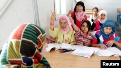 Syrian refugee children attend a class during the opening of a new school at the Al Zaatri refugee camp in the Jordanian city of Mafraq, near the border with Syria June 4, 2013.