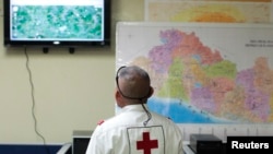 A member of El Salvador's Red Cross observes a screen after a magnitude 7.3 earthquake struck late on Monday, at a Red Cross office in San Salvador, October 13, 2014.