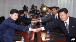 FILE - Lee Sang-min, chief of a South Korean delegation to a joint committee in charge of running the Kaesong Industrial Complex (l) shakes hands with his North Korean counterpart Pak Chol Su during a meeting to discuss minimum wage issues of North Korean