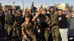 Iraqi security forces and volunteers celebrate in front of Governorate Council Building in Kirkuk, Oct. 16, 2017.