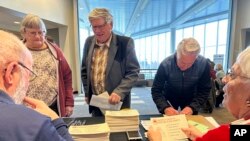 Claus, left, and Marsha Lembke, right, handle ballots for Republican caucus voters on March 4, 2024, at Bismarck State College in Bismarck, N.D. The college is one of 12 sites for the North Dakota Republican caucuses.