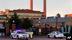 Police cars line the gate in the early morning as essential personnel only are allowed into a closed Washington Navy Yard in Washington, Sept. 17, 2013.