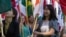 FILE - International students carry their national flags at the University of Missouri in Columbia, Missouri.