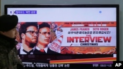 A South Korean army soldier walks near a TV screen showing an advertisement of Sony Picture's "The Interview," at the Seoul Railway Station in Seoul, Dec. 22, 2014. 
