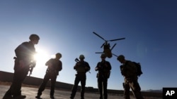 FILE - American soldiers wait on the tarmac in Logar province, Afghanistan. 