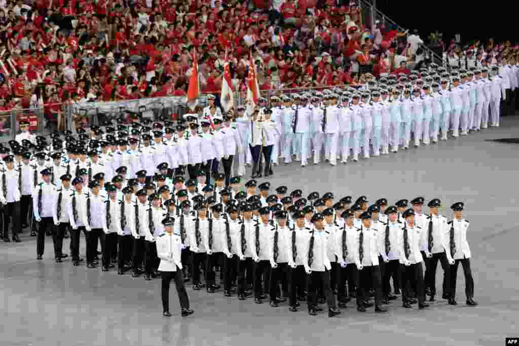 Các đơn vị quân đội diễn hành trên sân vận động quốc gia nhân kỷ niệm Ngày Quốc khánh Singapore. Singapore kỷ niệm Ngày Quốc khánh thứ 51 trong tình trạng an ninh chặt chẽ cả đường không, đường biển và đường bộ sau khi khám phá âm mưu tấn công của một phần tử cực đoan Indonesia.