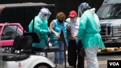 Empleados de salud ayudan a una paciente con síntomas de COVID-19 en la Ciudad de México.