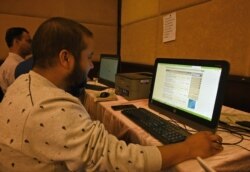 FILE - Journalists use Internet facilities sanctioned by the authorities, amid strict communications restrictions during a lockdown at a hotel in Srinagar on Oct. 3, 2019.
