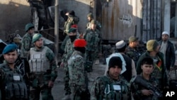 FILE - Afghan security forces inspect damages after clashes between Taliban fighters and Afghan forces in Kandahar, Afghanistan, Dec. 9, 2015. An overnight Taliban attack in Kandahar province killed 11 government soldiers, an Afghan Defense Ministry statement said Tuesday.
