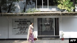 FILE - A woman walks past the former residence of Bangladesh’s 'founding father' Sheikh Mujibur Rahman, which is now a museum, in Dhaka, Bangladesh, Nov. 17, 2009.