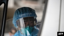An ambulance driver, wearing protective clothing is pictured after arriving at Princess Margaret Hospital in Hong Kong on Jan. 26, 2020. 