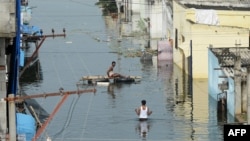 FILE - Flood-affected residents search for their belongings following heavy rains on the outskirts of Hyderabad, India, Oct. 20, 2020.