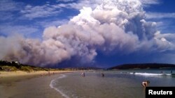 Smoke from a bushfire billows over beach goers at Carlton, about 20 kilometers (12 miles) east of Hobart, Australia, January 4, 2013.