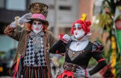 Dressed as characters from 'Alice in Wonderland' and wearing face masks against the spread of the novel coronavirus, Venezuelan migrants perform in Bogota, Colombia, on June 5, 2020.