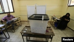 Election officials aElection officials wait for voters inside a polling station on the second day of voting in the Egyptian election in Cairo, May 27, 2014.