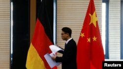 资料照：在北京举行中德经贸部长会议期间一名男子走过中国和德国国旗。（2016年11月1日）