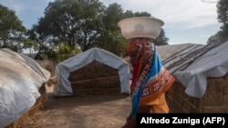 Mwanamke akipita katika vibanda vilivyoko katika kambi ya 25 de Junio wanakoishi watu waliolazimika kikumbia maeneo yao huko Metuge Disemba 9, 2020 kutoka eneo la magharibi la Cabo Delgado.