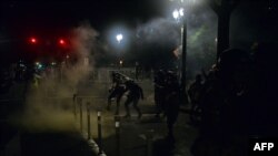 FILE - Police officers use tear gas during rally in Portland, Oregon, July 17, 2020. Rights activists and lawmakers expressed outrage over reports that federal agents in unmarked cars in the area were grabbing and detaining protesters off the streets.