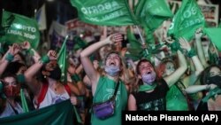  Abortion-rights activists watch live video streaming of lawmakers in session, outside Congress in Buenos Aires, Argentina, Wednesday, Dec. 30, 2020. (AP Photo/Natacha Pisarenko)
