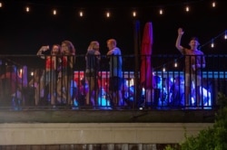 Patrons stand on the Bear Trap's rooftop bar on The Strip, the University of Alabama's bar scene, Aug. 15, 2020, in Tuscaloosa, Alabama.