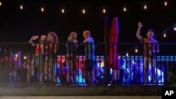Patrons stand on the Bear Trap's rooftop bar on The Strip, the University of Alabama's bar scene, Aug. 15, 2020, in Tuscaloosa, Alabama.