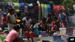 In this March 10, 2018 photo, Waraos from Venezuela prepare meals in an outdoor area of a shelter in Pacaraima, the main entry point for Venezuelans, in the Brazilian northern state Roraima. (AP Photo/Eraldo Peres)