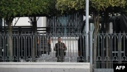 A soldier looks out from the City Hall compound in Yangon on Feb. 1, 2021, as Myanmar's military detained the country's de facto leader Aung San Suu Kyi and the country's president in a coup. 