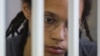 Pebasket AS Brittney Griner duduk di balik sel terdakwa dalam persidangan pembacaan putusan atas kasus narkoba yang menjeratnya. Persidangan digelar di Khimki, Moskow, Rusia, pada 4 Agustus 2022. (Foto: Reuters/Evgenia Novozhenina)