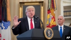 President Donald Trump, accompanied by Vice President Mike Pence, speaks during a signing ceremony for executive orders regarding trade in the Oval Office at the White House, March 31, 2017, in Washington. 