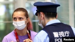 នាងKrystsina Tsimanouskaya កីឡាការិនី​តំណាង​ប្រទេស​បេឡារុស និយាយ​ជាមួយ​នឹង​មន្ត្រី​ប៉ូលិស​នៅ​អាកាសយានដ្ឋាន​អន្តរជាតិ Haneda ក្នុង​ទីក្រុង​តូក្យូ ប្រទេស​ជប៉ុន ថ្ងៃទី១ ខែសីហា ឆ្នាំ២០២១។