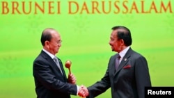 Burmar's President Thein Sein (L), chairman of the next ASEAN Summit, shakes hand with Brunei's Sultan Hassanal Bolkiah after receiving the ASEAN Gavel during the Closing Ceremony of the 23rd ASEAN Summit, Bandar Seri Begawan, Brunei, Oct. 10, 2013. 