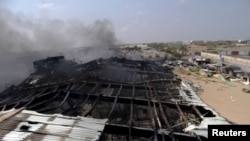 Smoke rises from a milk factory hit by an airstrike in Yemen's western port city of Houdieda, April 1, 2015. 