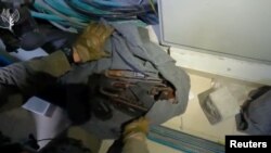 Izraelski vojnik pokazuje oružje i opremu koji su pronađeni u bolničkom kompleksu Al Šifa u Gazi (Foto: Israel Defense Forces/Handout via REUTERS)