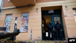 Policemen stand on Nov. 23, 2023 in front of a house in Berlin's Friedrichshain district, as a raid was underway against Hamas and another Palestinian organization which are banned in the country.
