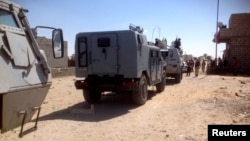 Army officers and soldiers check the area where rocket-propelled grenades hit a bus in El-Arish city, in North Sinai, July 15, 2013. 