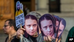 A man sells Greta Thunberg masks during a climate protest rally in Santiago, Chile, Sept. 27, 2019.
