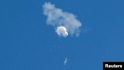 Puing-puing balon mata-mata yang diduga milik Cina tampak berhamburan jatuh ke laut setelah ditembak jatuh di lepas pantai di Pantai Surfside, Carolina Selatan, AS 4 Februari 2023.
