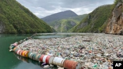 In this photo taken on Tuesday, April 23, 2019, plastic bottles and other garbage float in the river Drina near Visegrad, eastern Bosnia-Herzegovina. (AP Photo/Eldar Emric)