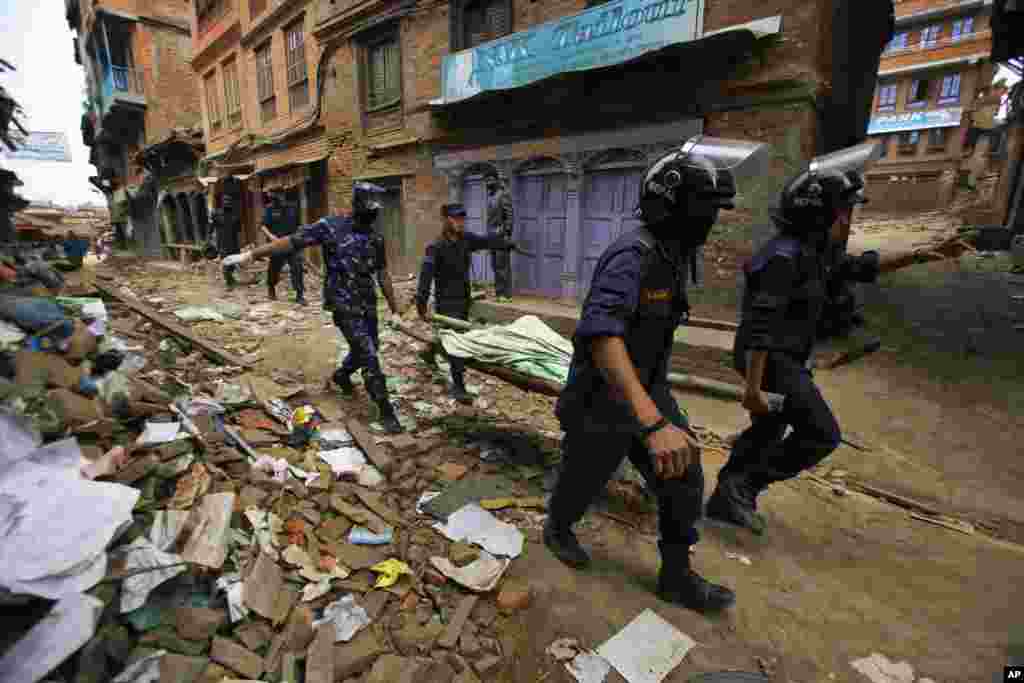 Nepalese rescue team carry on a stretcher the body of a victim recovered from the debris of a building that collapsed after an earthquake in Bhaktapur, near Kathmandu, Nepal.