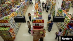FILE - People shop in a supermarket inside a department store in Bangkok.