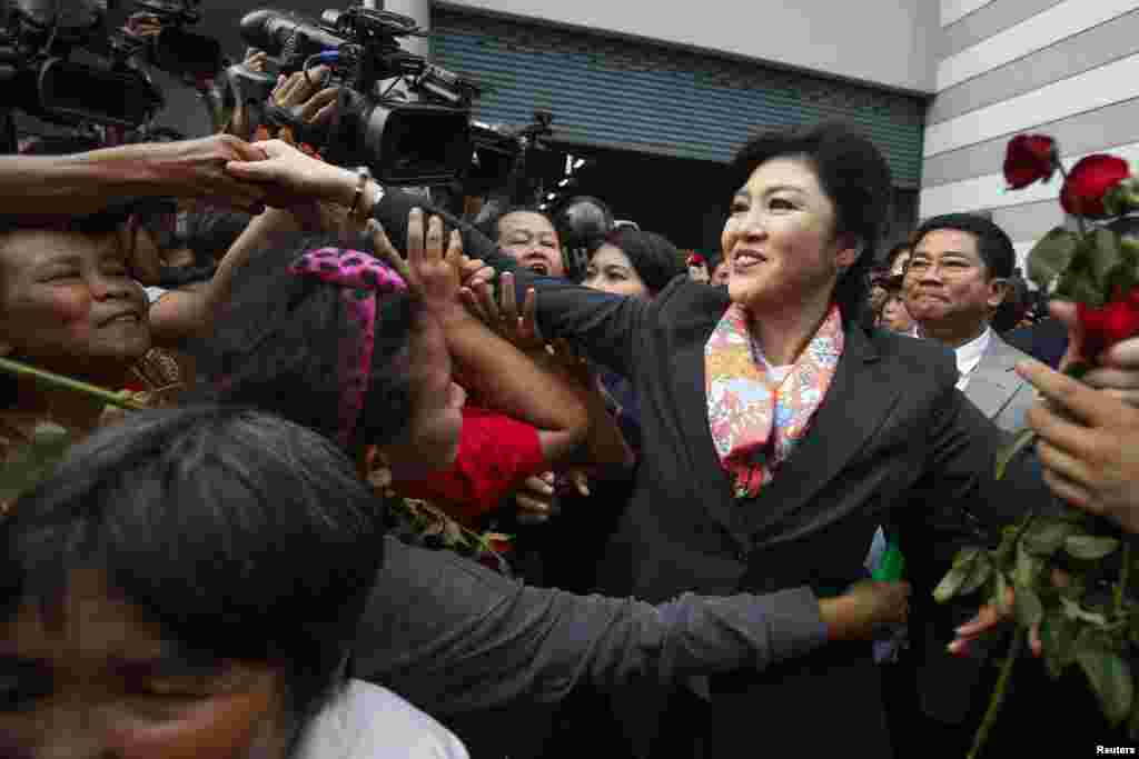 Thailand's Prime Minister Yingluck Shinawatra greets her supporters as she leaves the Permanent Secretary of Defence office in Bangkok, May 7, 2014.
